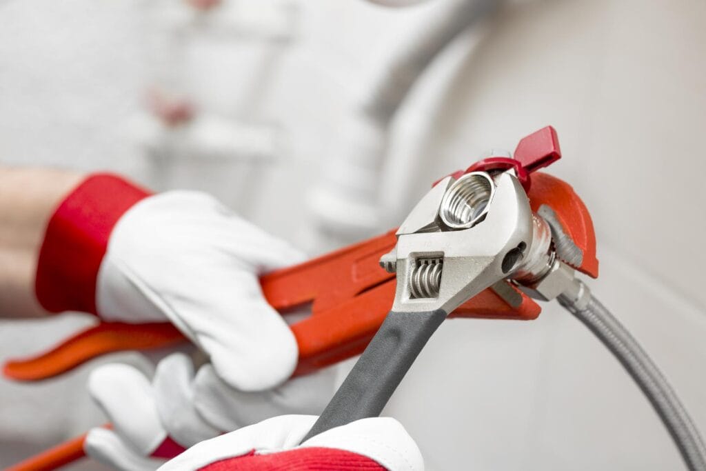 Plumber holding pipe wrenches for an emergency repair in Port Charlotte