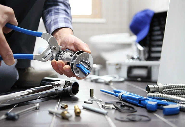 Technician repairing a plumbing fixture with professional tools in Port Charlotte