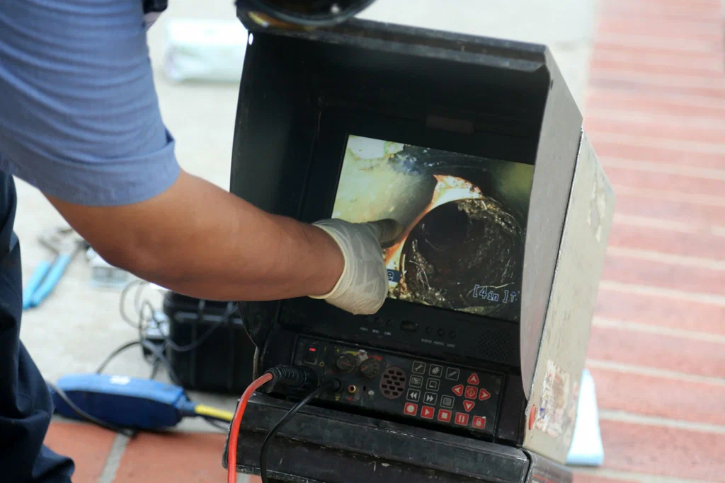 Technician viewing a drain inspection camera in Port Charlotte