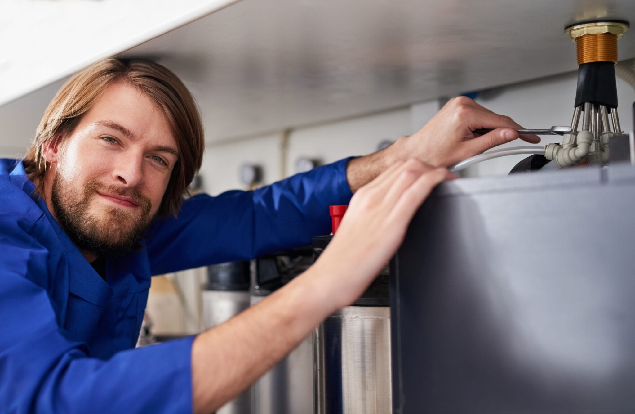 Technician servicing a residential water heater tank in Port Charlotte