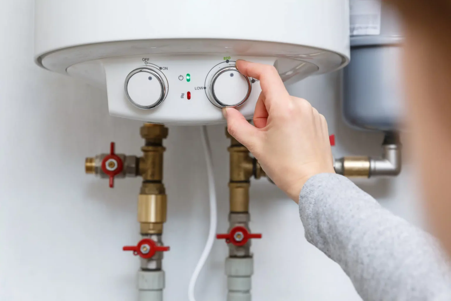 Homeowner adjusting the temperature controls on a water heater in Port Charlotte